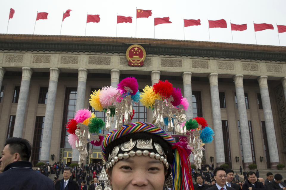FILE- In this March 4, 2018, file photo, an ethnic minority delegate leaves from the Great Hall of the People on the eve of the annual legislature's opening session in Beijing. Thousands of delegates from around China are gathering in Beijing for annual session of the country's rubber-stamp legislature and its advisory body, an event characterized more by the authoritarian ruling Communist Party leadership's desire to communicate its message than any actual discussion or passage of laws.(AP Photo/Ng Han Guan, File)
