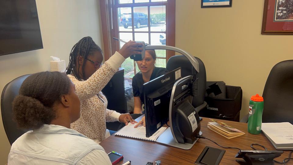 Kyri Boudin learning to use an EMV device with Sight Savers America’s staff