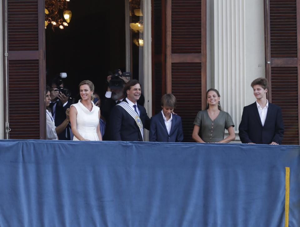 Uruguay's new President Luis Lacalle Pou, second left, his wife, Lorena Ponce de León, right, and their sons Luis Alberto Lacalle Ponce de León, third from left, Violeta Lacalle Ponce de León, second from right and Manuel Lacalle Ponce de León, right, stand together at the presidential balcony after Lacalle Pou's inauguration in Montevideo, Uruguay, Sunday, March 1, 2020. (AP Photo/Matilde Campodonico)