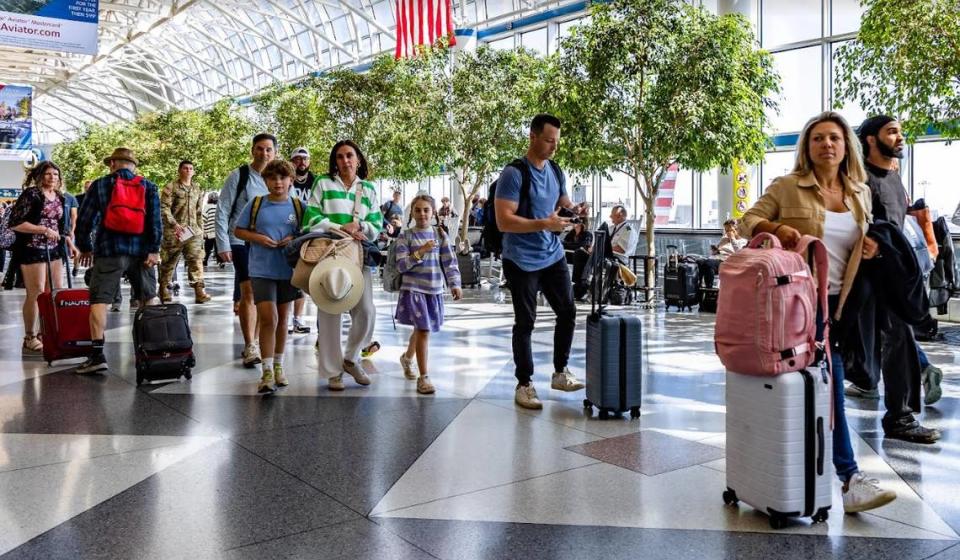 Passengers walk through Charlotte Douglas International Airport. American Airlines and CLT officials are expecting to break records this summer.