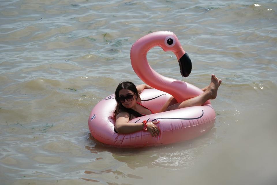 A beachgoer floats in a flamingo rubber ring in the sea at Southend-on-Sea (Yui Mok/PA) (PA Wire)