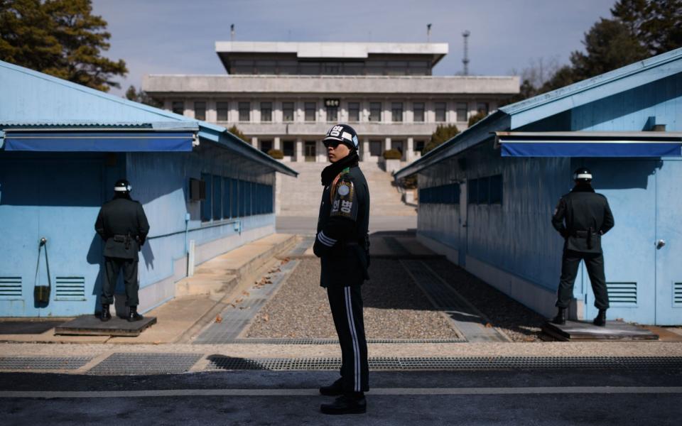 A South Korean soldier stands guard before the military demarcation line and North Korea's Panmun Hall, in the truce village of Panmunjom - AFP