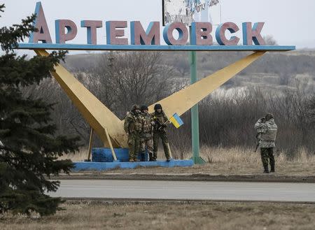 Members of Ukrainian armed forces take pictures with a sign near Artemivsk, eastern Ukraine, March 3, 2015. REUTERS/Gleb Garanich