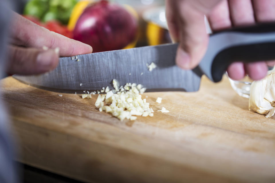 chopping garlic on a cutting board