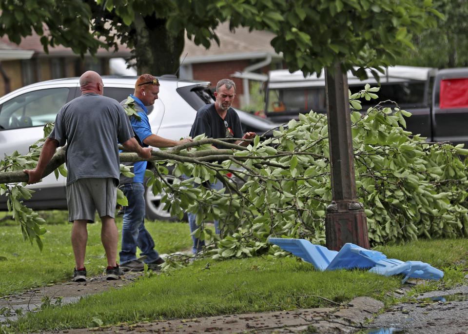 This Sunday, June 16, 2019, photo people clean up in Beech Grove, Ind., after a tornado moved through the area. Weather officials say severe storms in central Indiana caused floods and produced several tornadoes. (Kelly Wilkinson/The Indianapolis Star via AP)