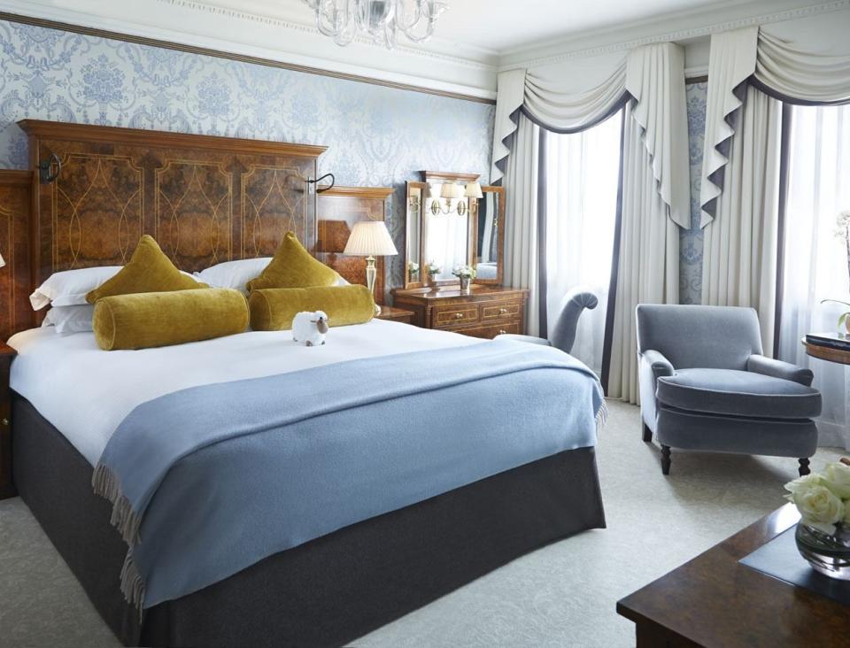 luxury double bed with blue armchair at the goring