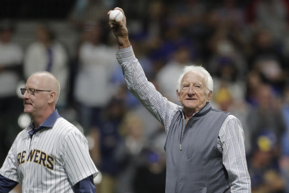 Broadcaster Bob Uecker, right, waves to the crowd after throwing out the ceremonial first pitch before a baseball game between the Milwaukee Brewers and the New York Mets Saturday, Sept. 25, 2021, in Milwaukee. (AP Photo/Aaron Gash)