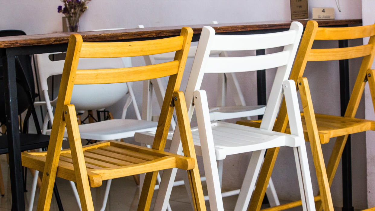 Two brown wood chair and one white wood chair from back.