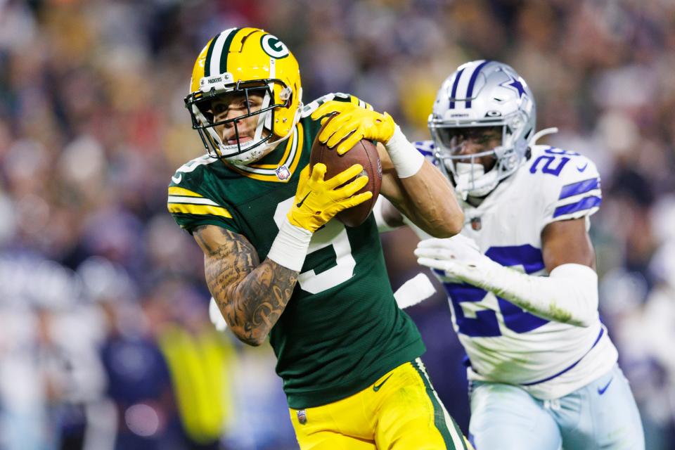 Green Bay Packers wide receiver Christian Watson (9) rushes with the football in front of Dallas Cowboys cornerback DaRon Bland (26) before scoring a touchdown during the fourth quarter at Lambeau Field.