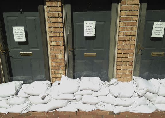 Sandbags and an evacuation warning sign are seen against the doors of apartments near the Tar River in Greenville, North Carolina, Oct. 11, 2016.