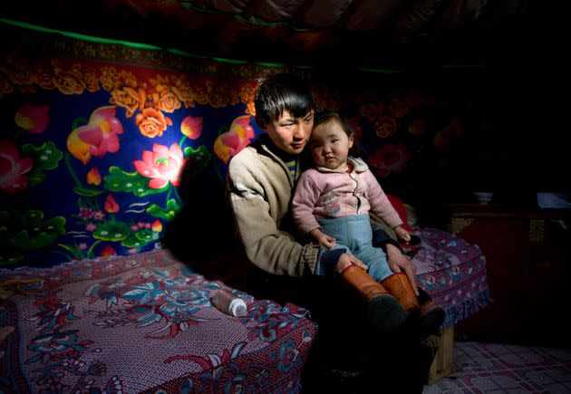 A 17-year-old Mongolian herder, Sukhbaatar, sits with niece Altantsetseg inside their 