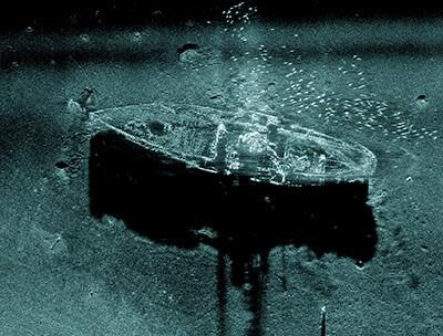 Synthetic aperture sonar image of the steamship Portland draped in fishing gear with a school of fish swimming overhead. / Credit: NOAA/SBNMS and Applied Signal Technology, Inc.