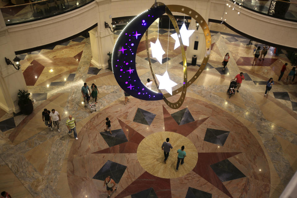 People walk inside a shopping mall with Ramadan decorations.