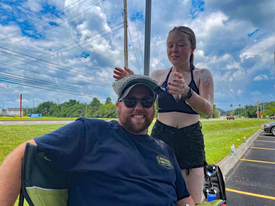 A band student comes from nowhere to place a cloth on Assistant Band Director Chuck Brock, bringing out the good sport in him at the annual car wash fundraiser for Hardin Valley band’s Disney World trip at Food City on Middlebrook Pike Saturday, July 22, 2023.