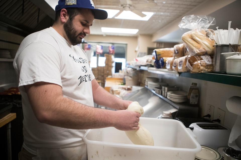 Nicholas Vouras folds pizza dough at Kozy Korner Friday, April 8, 2022. 