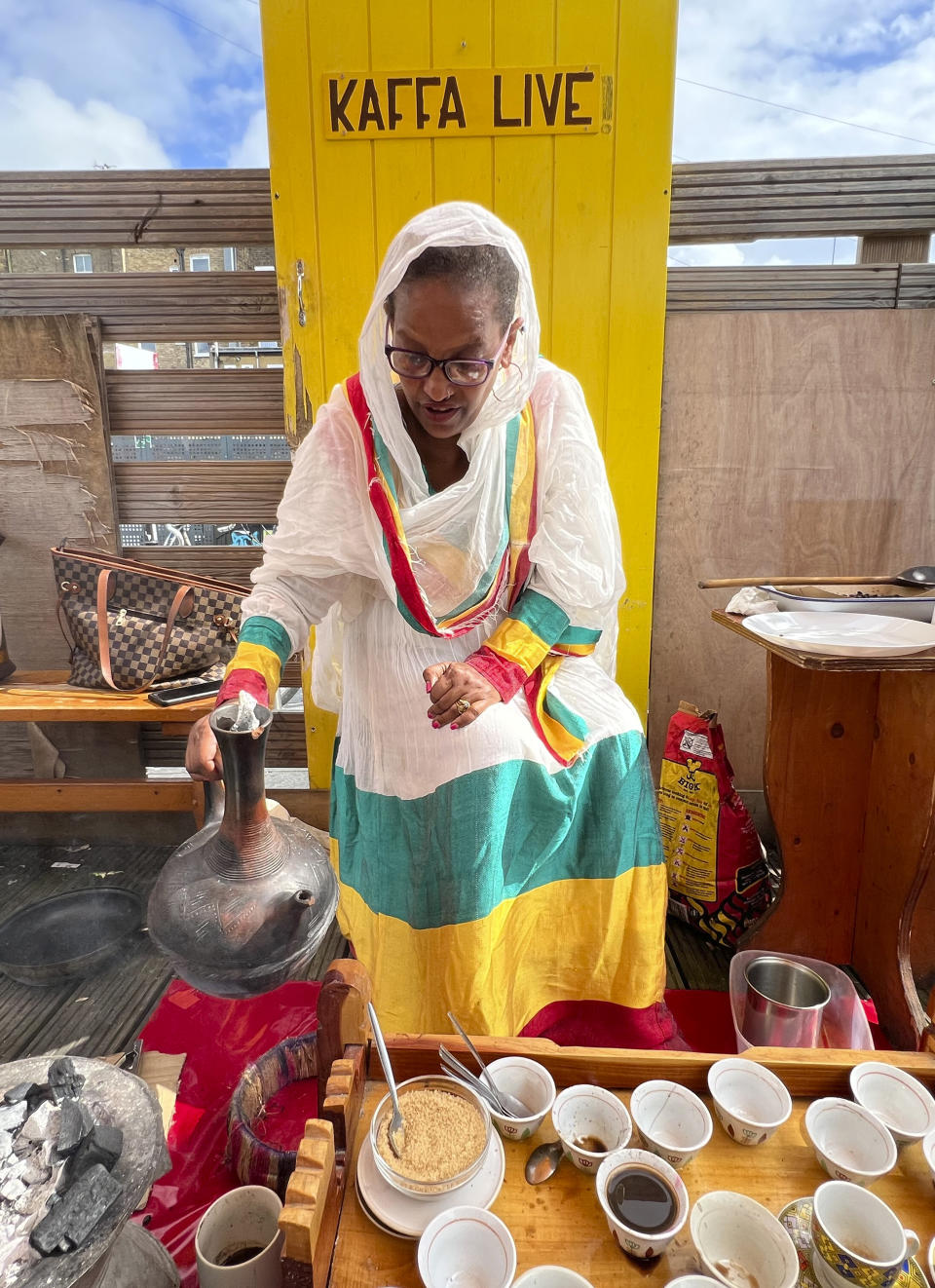 Emebyt Demke, 51, sets down a jebena, or Ethiopian clay coffee pot, after pouring coffee into a small, traditional coffee cup, also known as a sini, at Kaffa Coffee in East London on Friday, Sept. 1, 2023. The London-based International Coffee Organization has declared this Sunday, Oct. 1, as International Coffee Day. (AP Photo/Almaz Abedje)