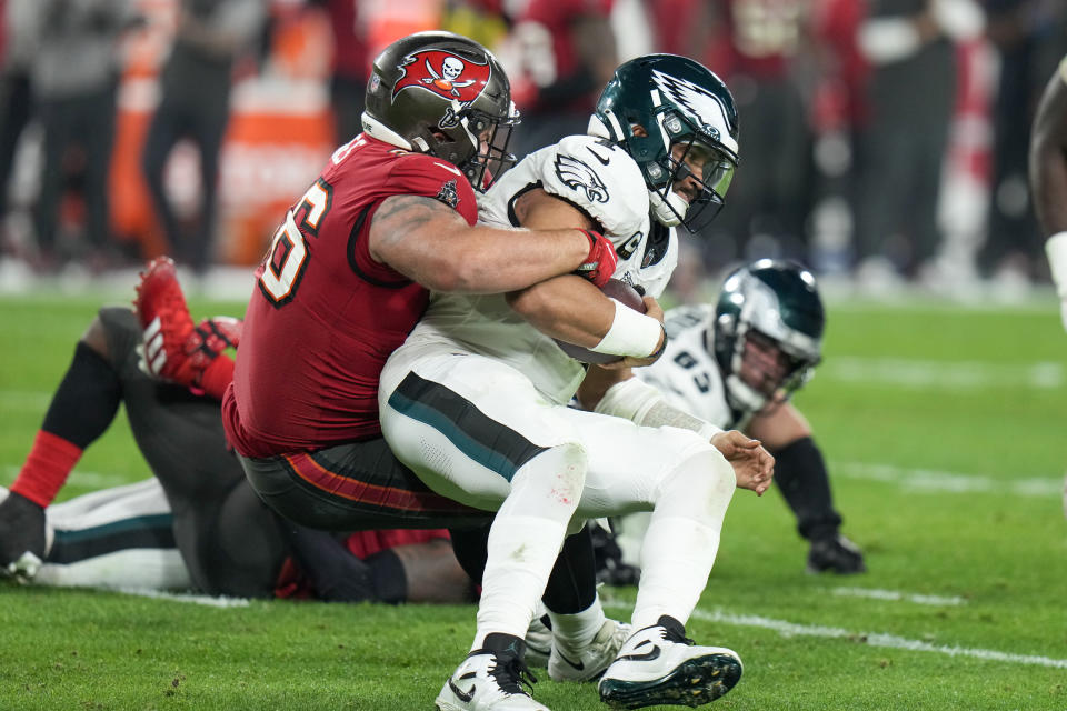 Philadelphia Eagles quarterback Jalen Hurts, right, is sacked by Tampa Bay Buccaneers defensive tackle Greg Gaines during the second half of an NFL wild-card playoff football game, Monday, Jan. 15, 2024, in Tampa, Fla. (AP Photo/Chris O'Meara)