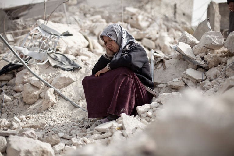 A woman sits in the rubble of her house in the Tariq al-Bab district of the northern city of Aleppo on February 23, 2013. Syria has been locked in a 23-month-long conflict in which the United Nations estimates over 70,000 people have been killed