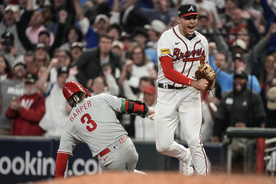 Atlanta Braves first baseman Matt Olson (28) reacts to getting the final out by forcing out Philadelphia Phillies' Bryce Harper (3) on a fly ball in the nineth inning of Game 2 of a baseball NL Division Series, Monday, Oct. 9, 2023, in Atlanta. The Atlanta Braves won 5-4. (AP Photo/John Bazemore)
