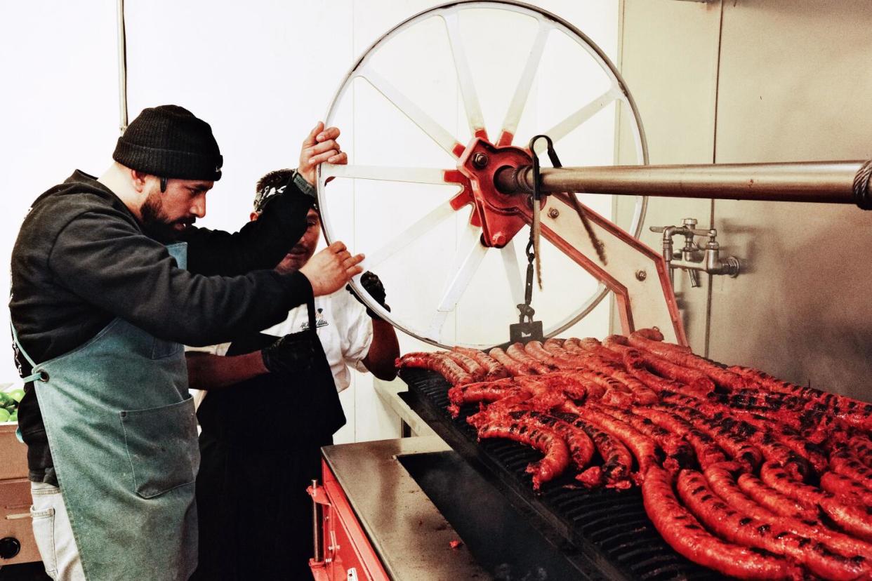 Owner Victor Villa mans the grill, cooking fresh chorizo, at Villa's Tacos in Grand Central Market.