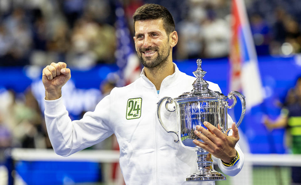 Novak Djokovic, pictured here wearing a '24' jacket as he celebrates with the US Open trophy.