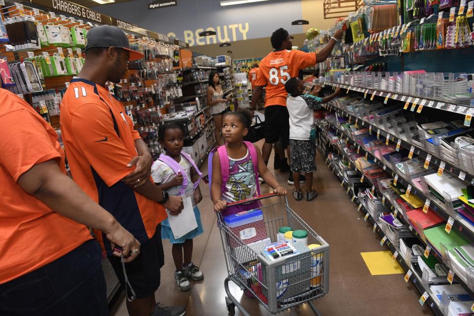 <p>Young Alize Keys, middle right, 6 looks to Denver Broncos wide receiver Jordan Norwood, #11, for some guidance as they shop for school supplies at King Soopers Marketplace on July 25, 2016 in Parker, Colorado. </p>