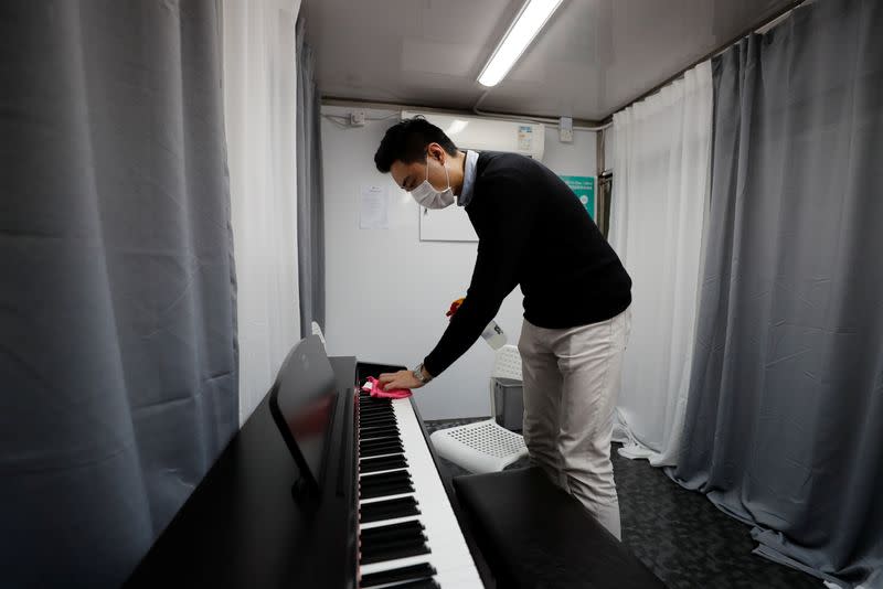 Curriculum officer Evan Kam cleans a mobile piano classroom before a piano class, on Ming’s Piano truck, following the novel coronavirus disease (COVID-19) outbreak, in Hong Kong