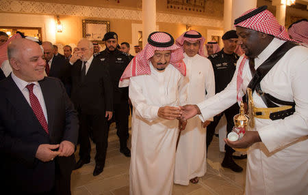 Saudi Arabia's King Salman bin Abdulaziz Al Saud is served coffee as he welcomes Iraqi Prime Minister Haider Al-Abadi in Riyadh, Saudi Arabia October 21, 2017. Bandar Algaloud/Courtesy of Saudi Royal Court/Handout via REUTERS ATTENTION EDITORS - THIS PICTURE WAS PROVIDED BY A THIRD PARTY.