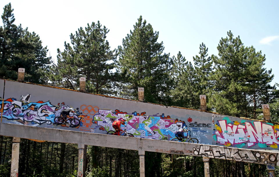 Downhill bikers Tarik Hadzic (L-R), Kemal Mulic and Kamer Kolar train on the disused bobsled track from the 1984 Sarajevo Winter Olympics on Trebevic mountain, Aug. 8, 2015. Abandoned and left to crumble into oblivion, most of the 1984 Winter Olympic venues in Bosnia's capital Sarajevo have been reduced to rubble by neglect as much as the 1990s conflict that tore apart the former Yugoslavia.