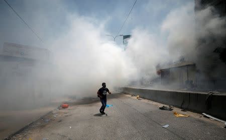 A Palestinian protester reacts to tear gas fired by Israeli troops during clashes near Qalandiya checkpoint near the West Bank city of Ramallah July 21, 2017. REUTERS/Mohamad Torokman