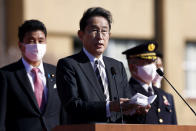 Japan's Prime Minister Fumio Kishida, center, speaks in front of troops of the Japan Self-Defense Forces during a review at the Japan Ground Self-Defense Force Camp Asaka in Tokyo, Japan, Saturday, Nov. 27, 2021. Kishida, at his first troop review Saturday, renewed his pledge to consider “all options,” including acquiring enemy base strike capability, and vowed to create a stronger Self-Defense Force to protect the country amid growing threats from China and North Korea. (Kiyoshi Ota/Pool Photo via AP)
