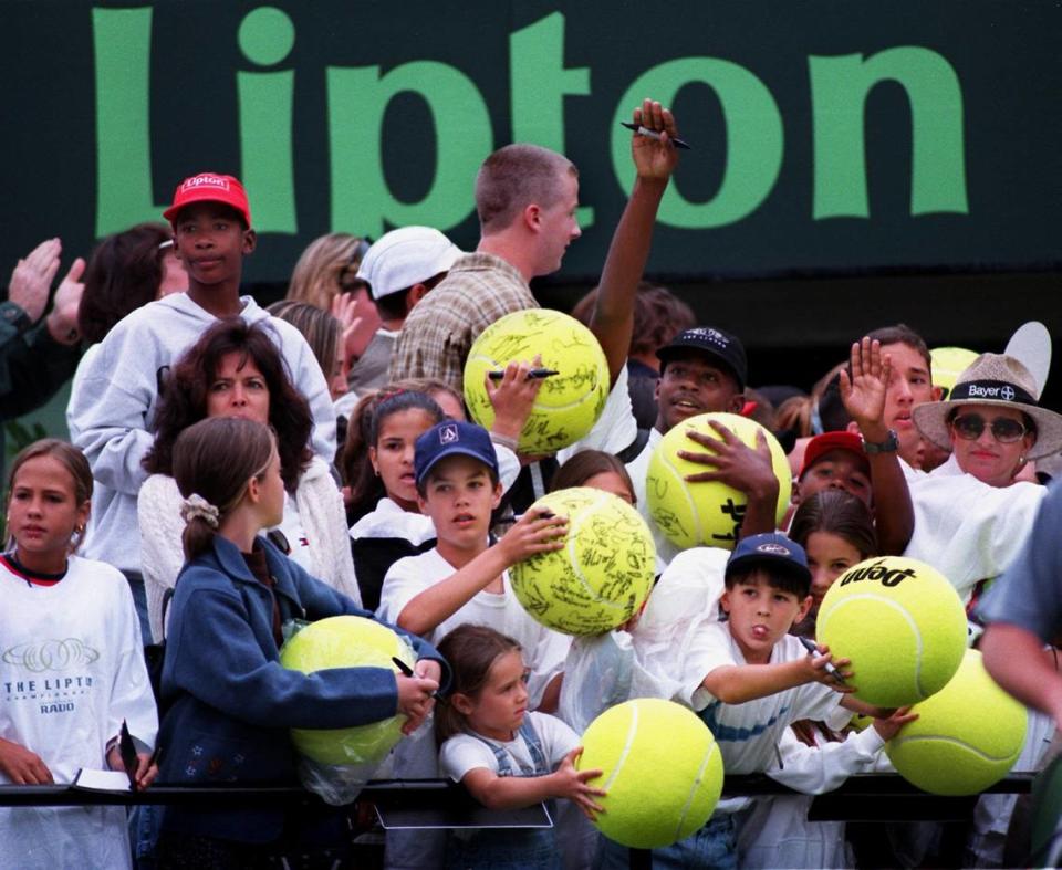 In 1998 at the Lipton Championship near Key Biscayne, young tennis fans hold oversized tennis balls as they wait for Andre Agassi to autograph them.