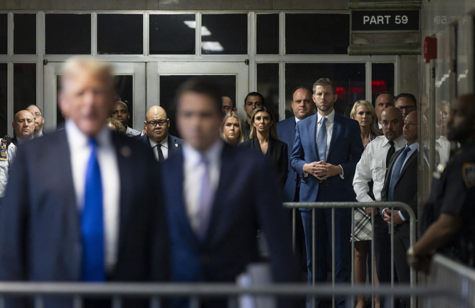 Eric Trum, fourth from right listens as his father former comments to members of the media after a jury convicted him of felony crimes for falsifying business records in a scheme to illegally influence the 2016 election, at Manhattan Criminal Court, Thursday, May 30, 2024, in New York. (Justin Lane/Pool Photo via AP)