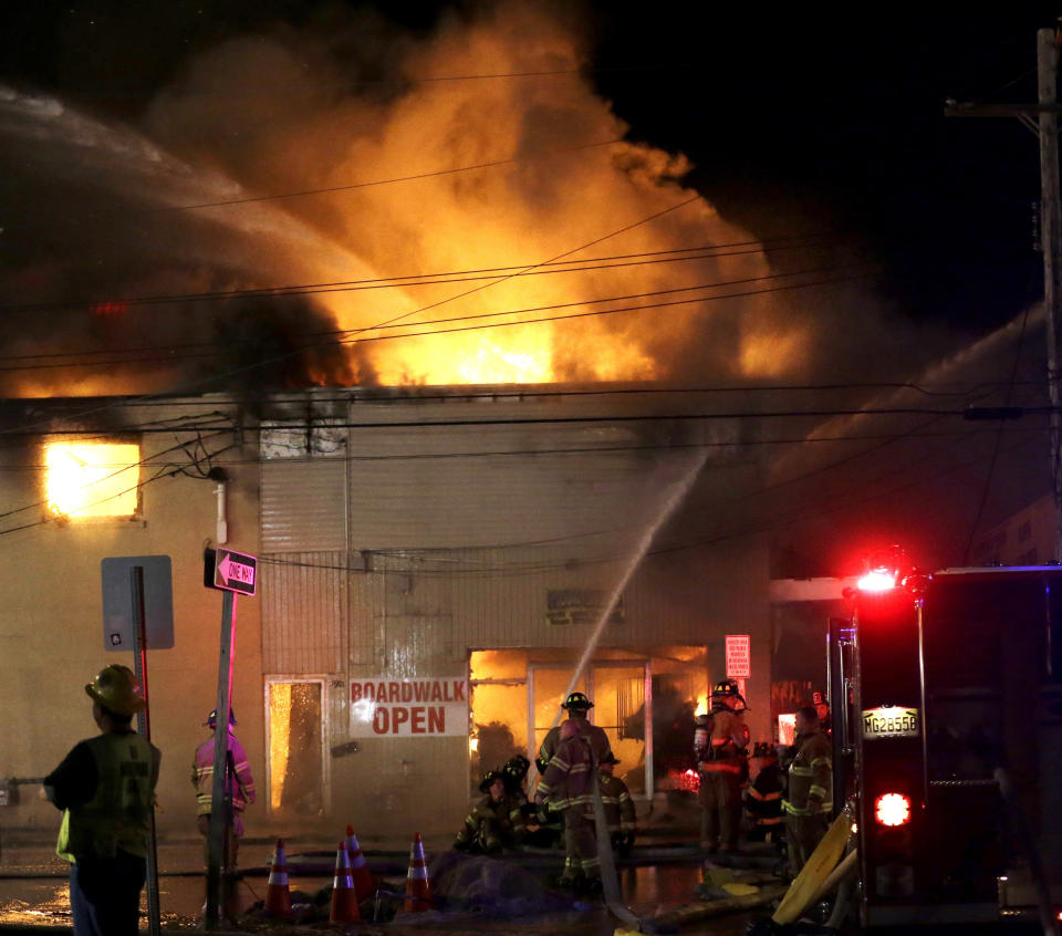 Firefighters battle a blaze in a building on the Seaside Park boardwalk on Thursday, Sept. 12, 2013, in Seaside Park, N.J. The fire began in a frozen custard stand on the Seaside Park section of the boardwalk and quickly spread north into neighboring Seaside Heights. (Julio Cortez/AP)