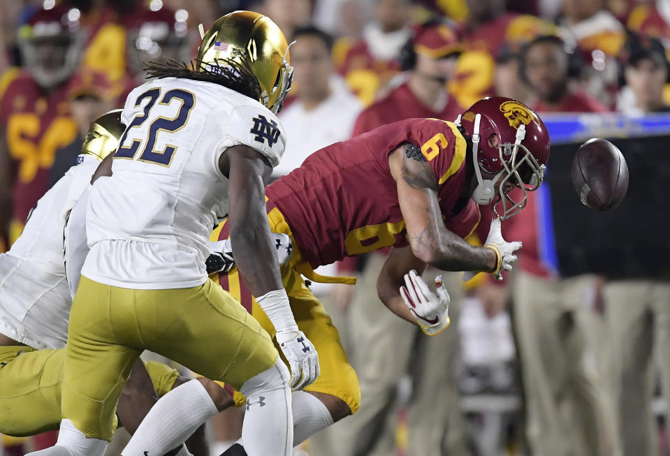 Notre Dame cornerback Troy Pride Jr., left, forces a fumble by Southern California wide receiver Michael Pittman Jr., right, as linebacker Asmar Bilal watches during the first half of an NCAA college football game Saturday, Nov. 24, 2018, in Los Angeles. Notre Dame recovered the ball. (AP Photo/Mark J. Terrill)