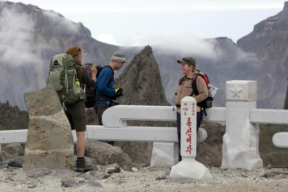 In this Saturday, Aug. 18, 2018, photo, Sinead of Australia, right, chats with Paula of Australia, left, and Tarjei Naess Skrede of Norway during a hike arranged by Roger Shepherd of Hike Korea on Mount Paektu in North Korea. Hoping to open up a side of North Korea rarely seen by outsiders, Shepherd, a New Zealander who has extensive experience climbing the mountains of North and South Korea is leading the first group of foreign tourists allowed to trek off road and camp out under the stars on Mount Paektu, a huge volcano that straddles the border that separates China and North Korea. (AP Photo/Ng Han Guan)