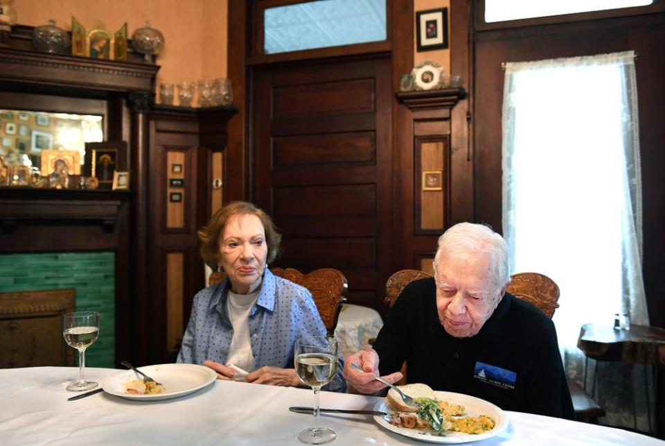 Jimmy Carter sits next to his wife, former First Lady Rosalynn Carter, while having dinner at the home of friend Jill Stuckey