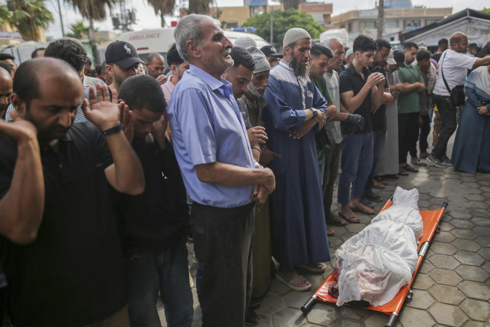 Palestinians pray next to the body of a relative killed in an Israeli airstrike, outside the morgue in Al-Aqsa Martyrs Hospital in Deir al Balah, the Gaza Strip, Monday, June 10, 2024. (AP Photo/Jehad Alshrafi)