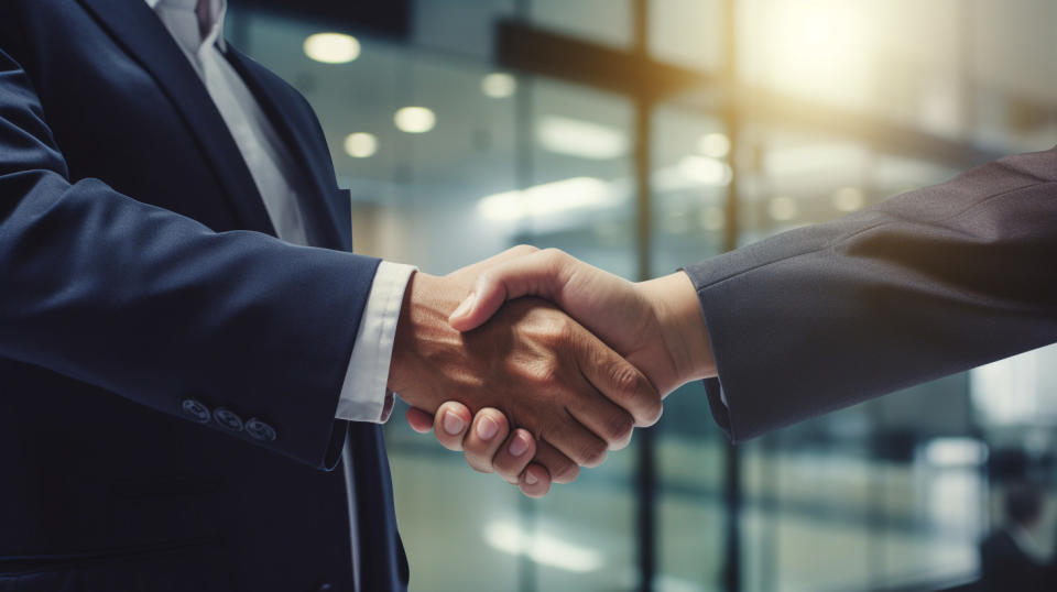 A senior executive shaking hands with a small business customer in a financial institution's lobby.