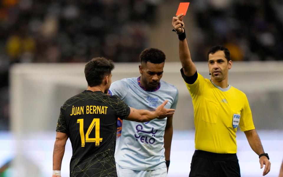 PSG's Juan Bernat receives a red card from the referee during a friendly match between a combined XI of Saudi Arabian teams Al Nassr and Al Hilal - AP