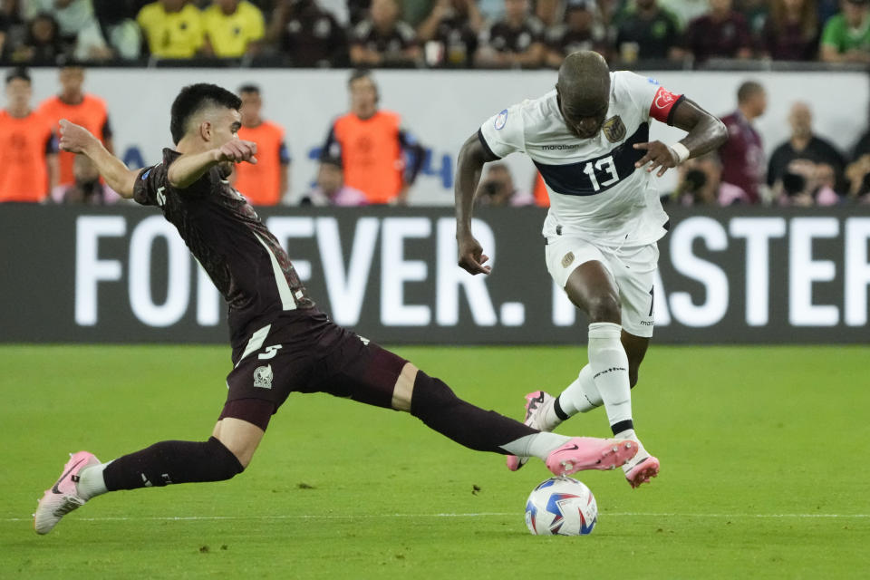 El mexicano Johan Vásquez (izquierda) disputa un balón ante el ecuatoriano Enner Valencia durante el partido de la Copa América en Glendale, Arizona, el domingo 30 de junio de 2024. (AP Foto/Rick Scuteri)