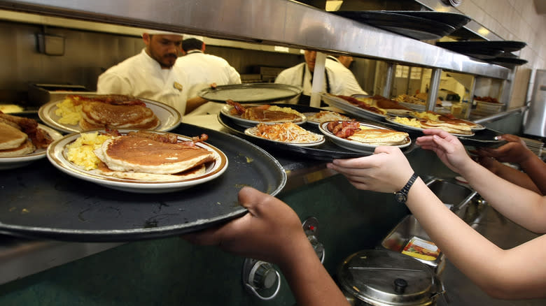 Denny's waitstaff grabbing pancakes