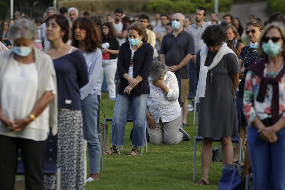 Worshippers attend an outdoor mass at the hippodrome in Cascais, outside Lisbon, Sunday, May 31, 2020. As the government eases the coronavirus lockdown rules, the Catholic Church in Portugal resumed the celebration of religious services Saturday with a set of safety rules to avoid the spread of COVID-19. (AP Photo/Armando Franca)