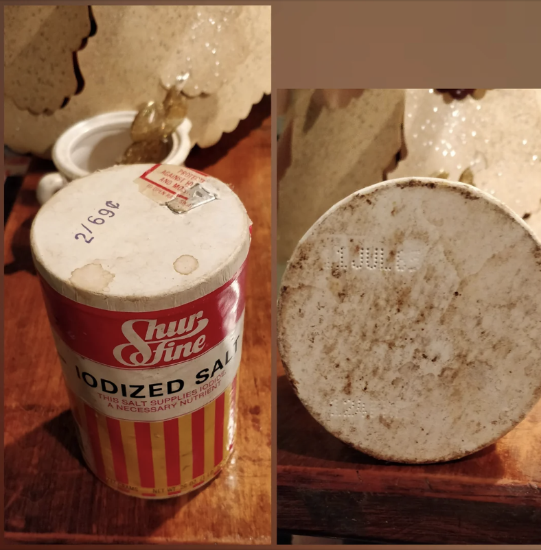 A canister of Shur Fine iodized salt with a red and yellow label is shown. The canister appears aged with some signs of wear and expiration date visible at the bottom