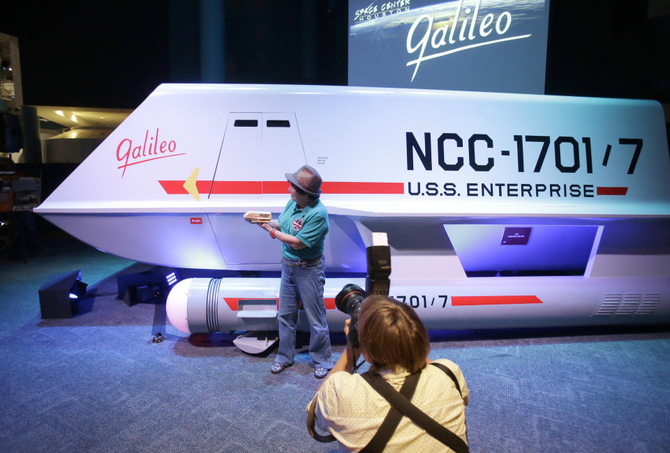 Candy Torres is photographed standing in front of the restored space shuttle Galileo from the 1960's television show Star Trek holding her plastic toy version of the vehicle at Space Center Houston Wednesday, July 31, 2013, in Houston. The restored shuttlecraft that crash-landed on a hostile planet in the 1967 episode "The Galileo Seven" was officially unveiled at the Space Center Houston before a crowd of die-hard Star Trek fans. (AP Photo/Pat Sullivan)