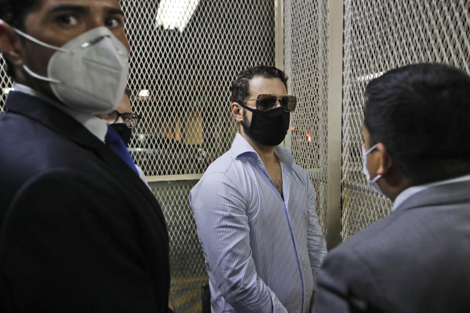 Ricardo Martinelli Linares, son of former Panamanian President Ricardo Martinelli, center, is accompanied by his lawyers before a hearing at the judicial court building in Guatemala City, Monday, July 6, 2020. Guatemalan police detained the Martinelli brothers, Ricardo and Luis Enrique, on an Interpol warrant for money laundering, as they attempted to board a private plane out of the country. (AP Photo/Moises Castillo)