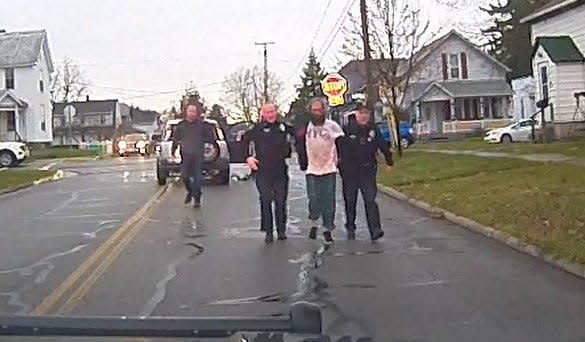 Bucyrus police Officer Devin Wireman and Lt. Scott Bursby escort the suspect back to Wireman's cruiser during a Nov. 11 shooting incident. This screen capture is from a Bucyrus Police Department dashcam video.