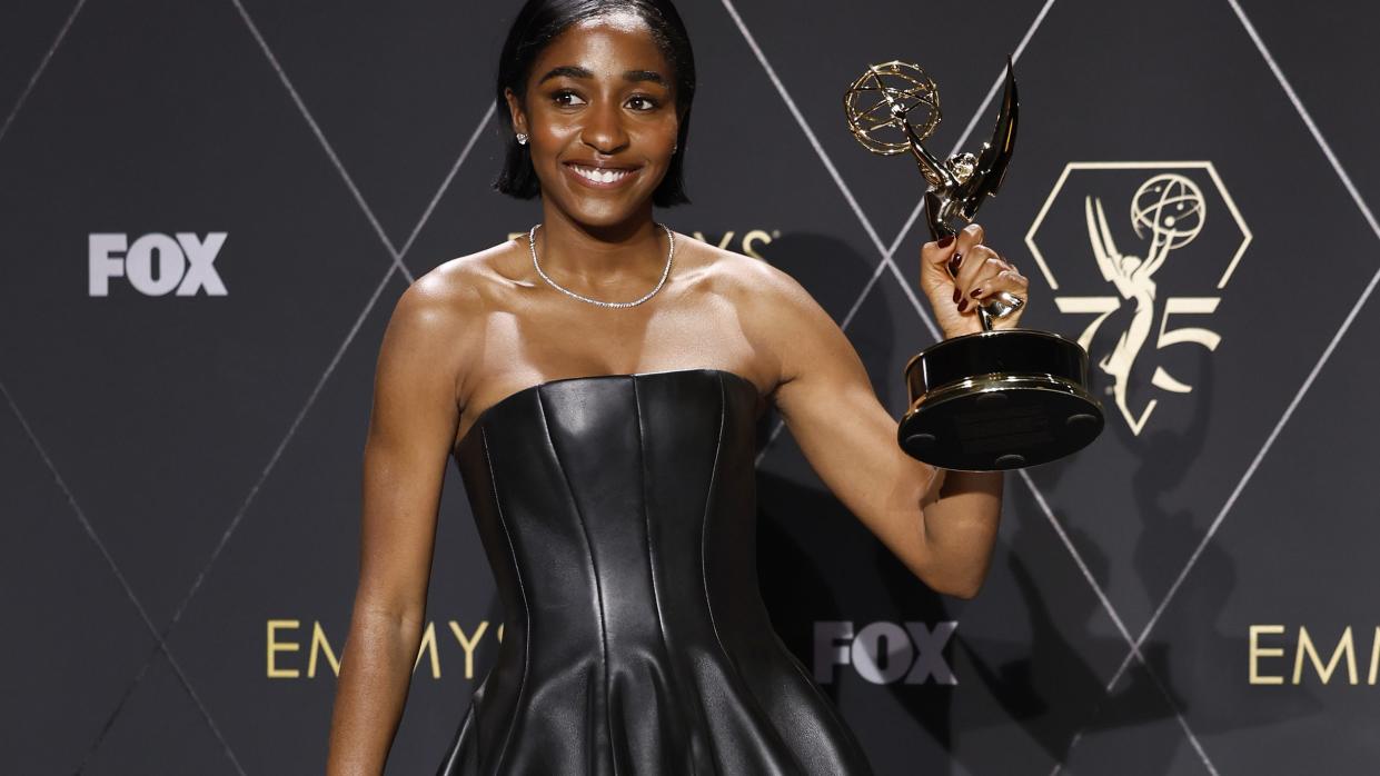 ayo edebiri backstage at the emmys holding up her trophy