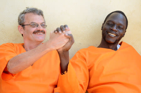 William John Endley, a South African national and adviser to South Sudanese rebel leader Riek Machar, and James Gatdet Dak, a former spokesman of the rebel leader, hold hands as they sit inside the prison in Juba, South Sudan November 2, 2018. REUTERS/Jok Solomun