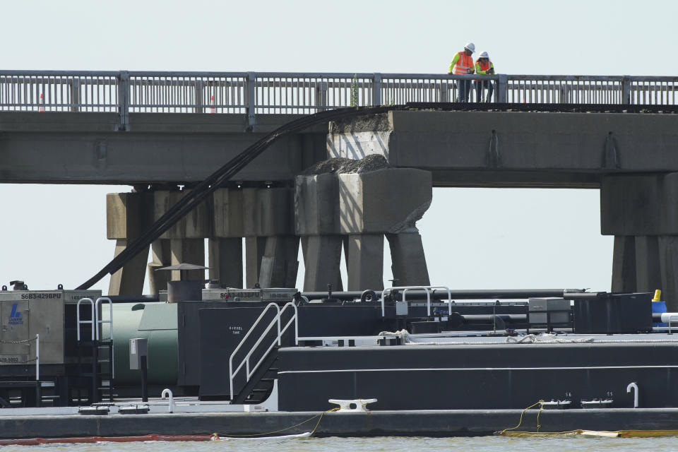 Officials respond after the Pelican Island Bridge was closed when a passing barge struck one of its supports, Wednesday, May 15, 2024, in Galveston, Texas. A barge slammed into a bridge pillar on Wednesday, spilling oil into surrounding waters and closing the only road to a smaller and separate island that is home to a university, officials said. (Jon Shapley/Houston Chronicle via AP)